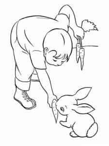 Boy feeds carrots to rabbit coloring page